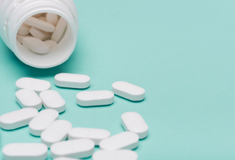 Antibiotics tub with pills spilling out